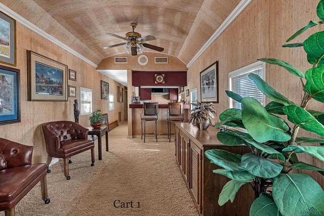 living area with ceiling fan, light colored carpet, ornamental molding, and vaulted ceiling