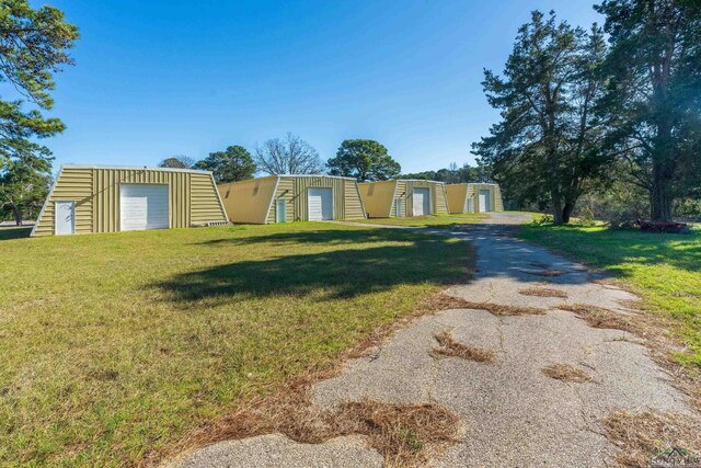 view of yard with a garage and an outbuilding