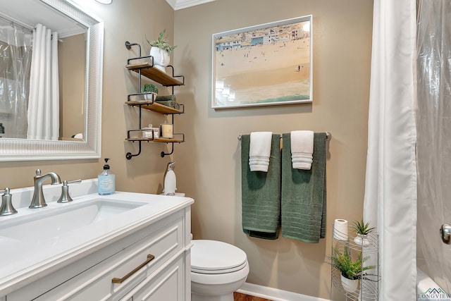 bathroom with ornamental molding, vanity, and toilet