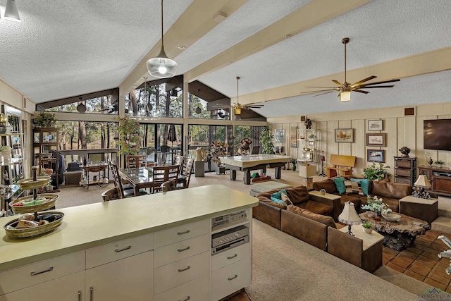 kitchen featuring a textured ceiling, light carpet, lofted ceiling with beams, and ceiling fan