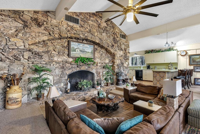 living room with a textured ceiling, ceiling fan, lofted ceiling with beams, and a stone fireplace