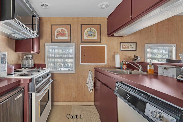 kitchen featuring stainless steel dishwasher, wooden walls, sink, and white range with electric stovetop