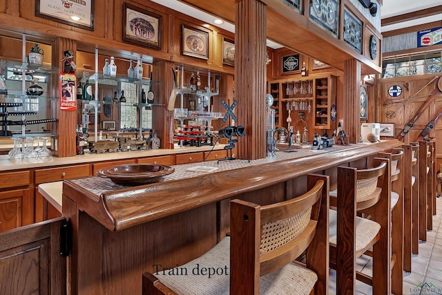 bar featuring wooden walls and light tile patterned flooring