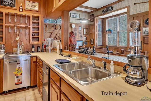 kitchen with sink, wooden walls, decorative light fixtures, and light tile patterned floors