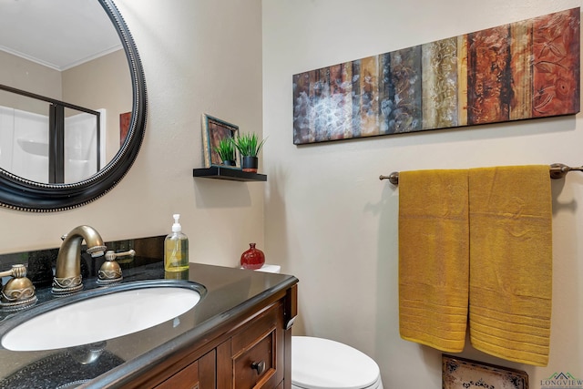 bathroom with toilet, an enclosed shower, ornamental molding, and vanity