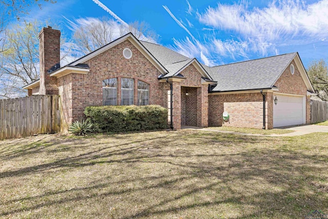 view of front facade featuring brick siding, an attached garage, a front yard, and fence