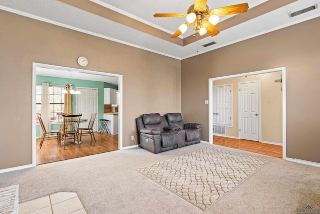 living room with carpet, visible vents, and ornamental molding