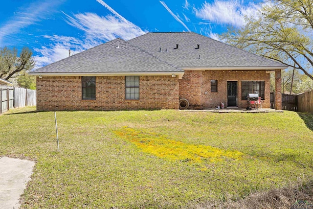 back of house with a patio area, a lawn, a fenced backyard, and roof with shingles