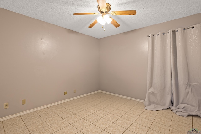 empty room featuring light tile patterned floors, baseboards, a textured ceiling, and a ceiling fan