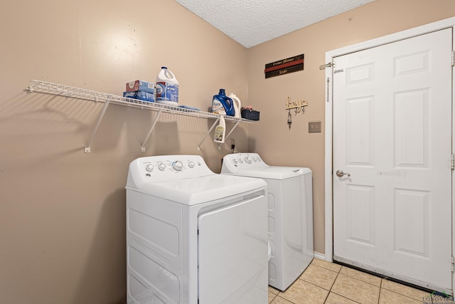 washroom featuring light tile patterned floors, a textured ceiling, independent washer and dryer, and laundry area