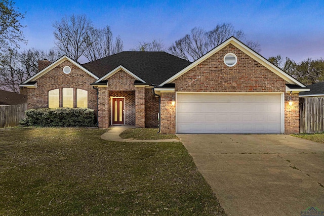 view of front of house featuring fence, an attached garage, concrete driveway, a lawn, and brick siding