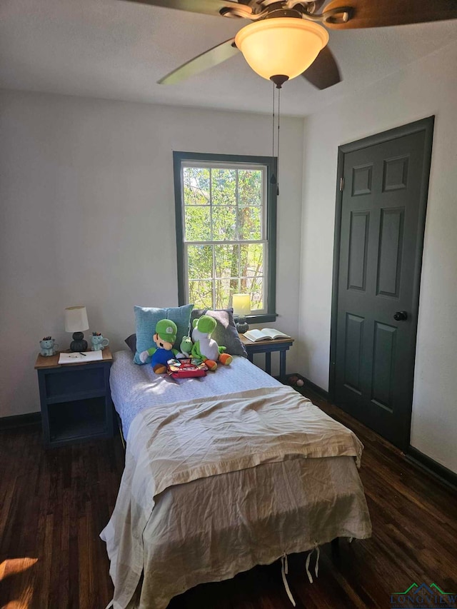 bedroom with ceiling fan and dark hardwood / wood-style floors