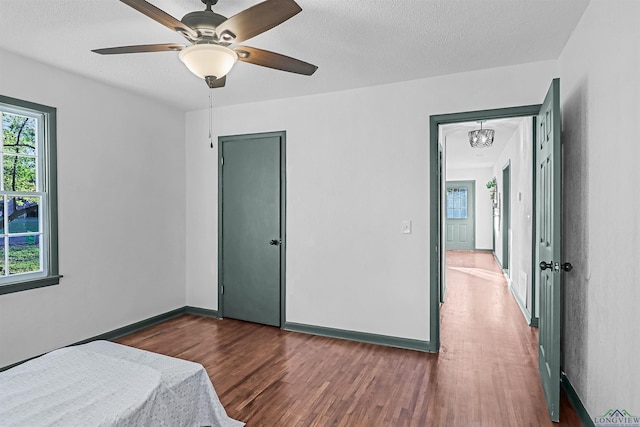 bedroom featuring ceiling fan, dark hardwood / wood-style floors, and a textured ceiling