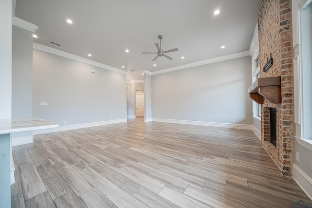 unfurnished living room featuring ceiling fan, crown molding, and a fireplace