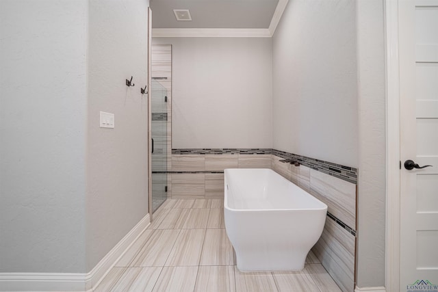 bathroom with ornamental molding, tile walls, and plus walk in shower