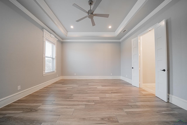 spare room featuring light hardwood / wood-style flooring, a raised ceiling, ceiling fan, and crown molding