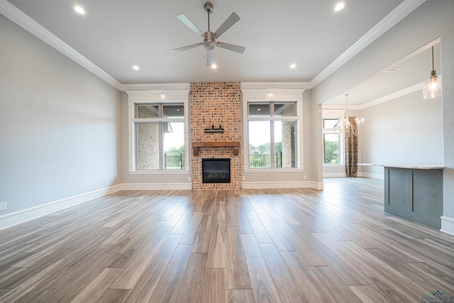 unfurnished living room featuring hardwood / wood-style flooring, plenty of natural light, and a brick fireplace