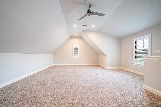 bonus room featuring carpet flooring, a textured ceiling, vaulted ceiling, and ceiling fan