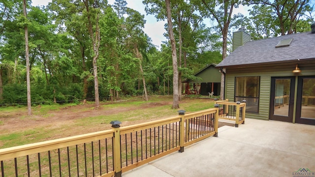 wooden deck featuring a lawn and a patio area