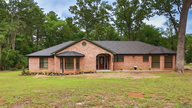 ranch-style house with brick siding, roof with shingles, and a front yard