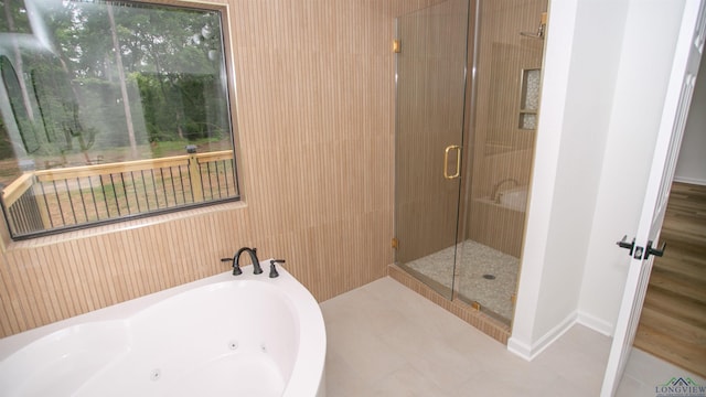 bathroom with a whirlpool tub, baseboards, tile patterned flooring, and a shower stall