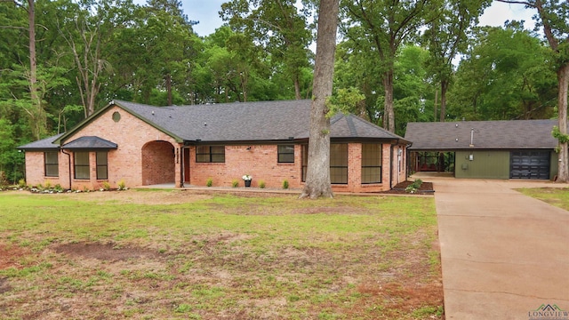 ranch-style home featuring roof with shingles, a front lawn, brick siding, an attached carport, and driveway
