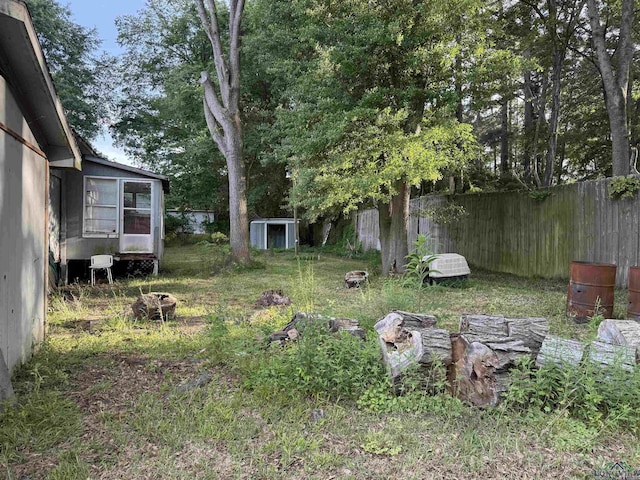 4604 Skyline Dr, Chandler, TX 75758 - view of yard with an outdoor fire pit, a shed, fence, an outbuilding, and a sunroom