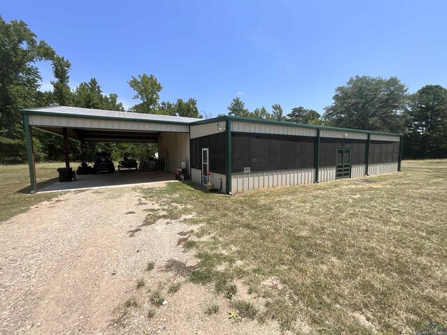 view of outdoor structure with a yard and a carport