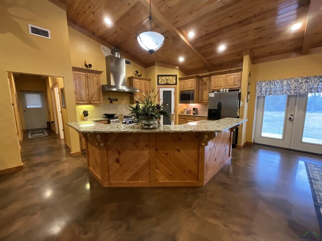 kitchen featuring a kitchen breakfast bar, a large island with sink, light stone counters, and wall chimney range hood