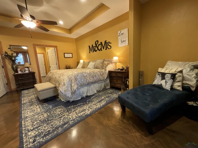 bedroom with ceiling fan and a tray ceiling