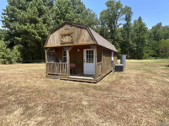 view of outdoor structure with a lawn and central AC