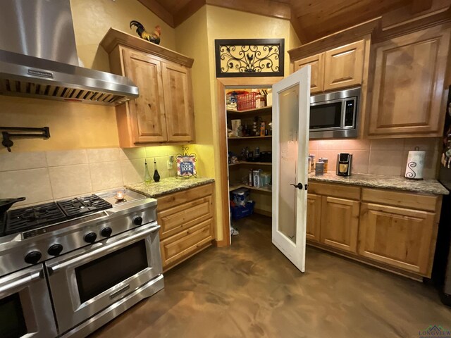 kitchen featuring light stone countertops, range hood, appliances with stainless steel finishes, and tasteful backsplash