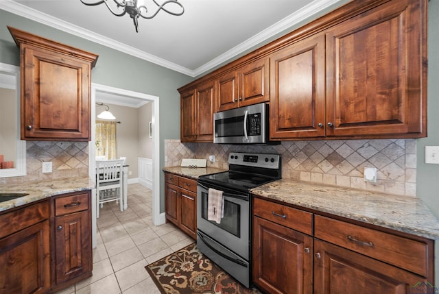 kitchen featuring tasteful backsplash, stainless steel appliances, crown molding, light tile patterned floors, and an inviting chandelier