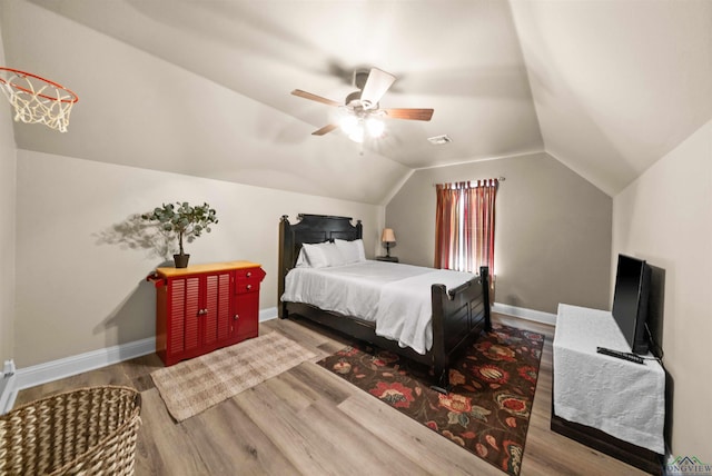 bedroom with hardwood / wood-style floors, ceiling fan, and vaulted ceiling