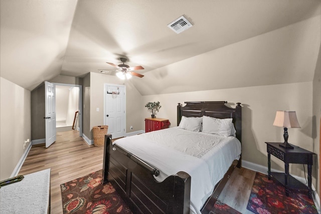 bedroom with hardwood / wood-style floors, ceiling fan, and vaulted ceiling