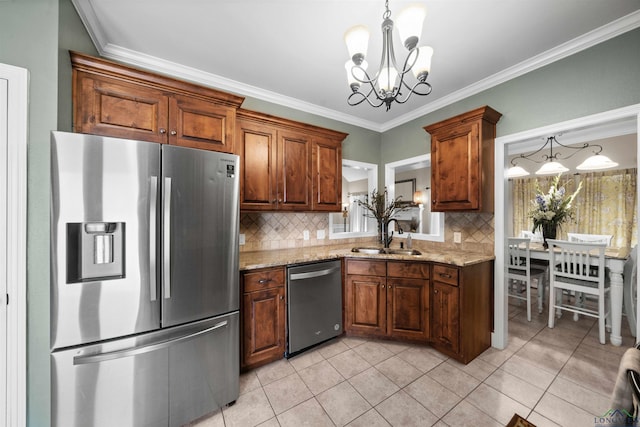 kitchen with sink, stainless steel appliances, a notable chandelier, decorative light fixtures, and decorative backsplash