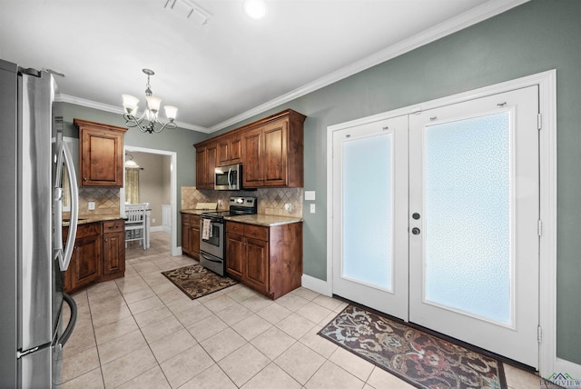 kitchen with appliances with stainless steel finishes, backsplash, light stone counters, crown molding, and a notable chandelier