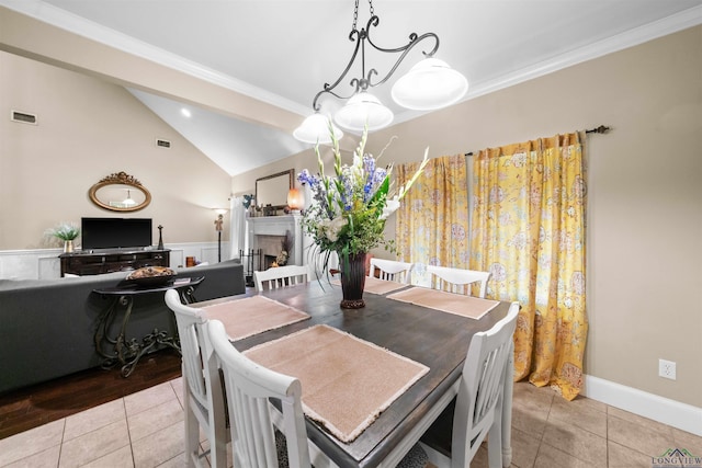 tiled dining space featuring a notable chandelier, lofted ceiling, and crown molding