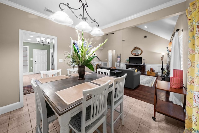 tiled dining room featuring lofted ceiling, crown molding, and an inviting chandelier