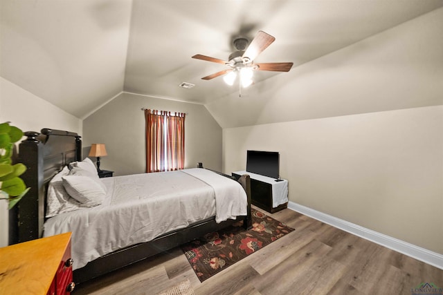 bedroom with ceiling fan, wood-type flooring, and lofted ceiling