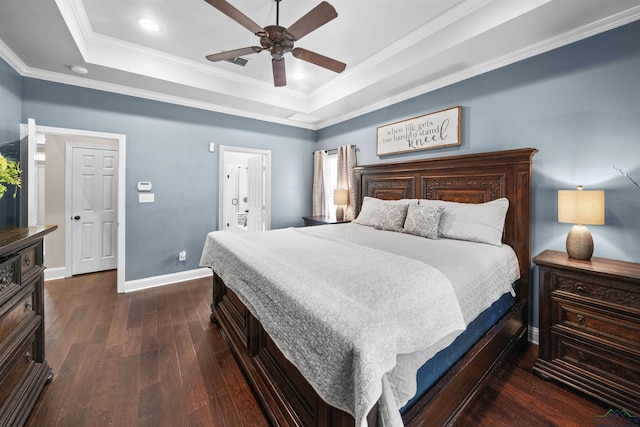 bedroom with dark hardwood / wood-style flooring, ensuite bathroom, a raised ceiling, ceiling fan, and crown molding