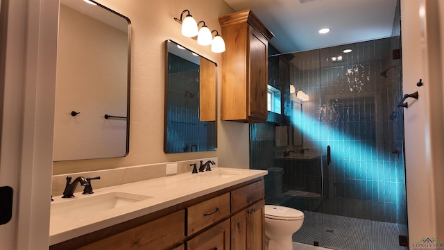 bathroom featuring double vanity, a stall shower, a sink, and toilet