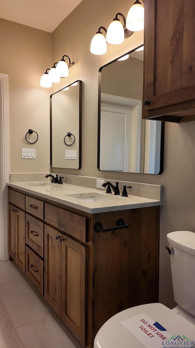 bathroom featuring a sink, toilet, and double vanity