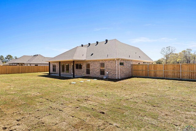 169 Andres Ln, Kilgore, TX 75662 - rear view of property featuring a fenced backyard, brick siding, a patio, and a lawn