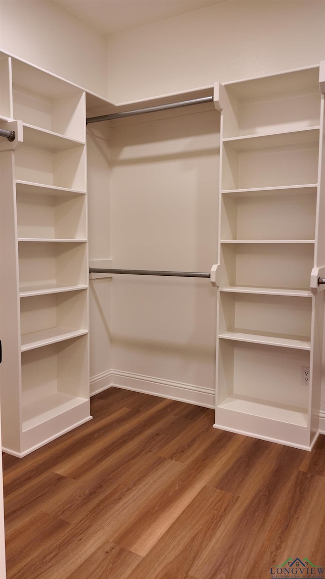 walk in closet with wood finished floors