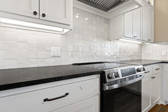 169 Andres Ln, Kilgore, TX 75662 - kitchen featuring dark countertops, tasteful backsplash, custom range hood, and electric range