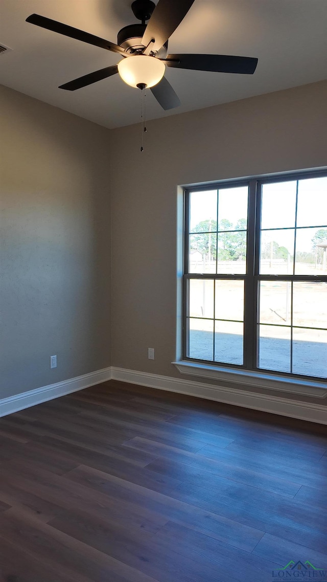 spare room with dark wood-style floors, baseboards, and a ceiling fan