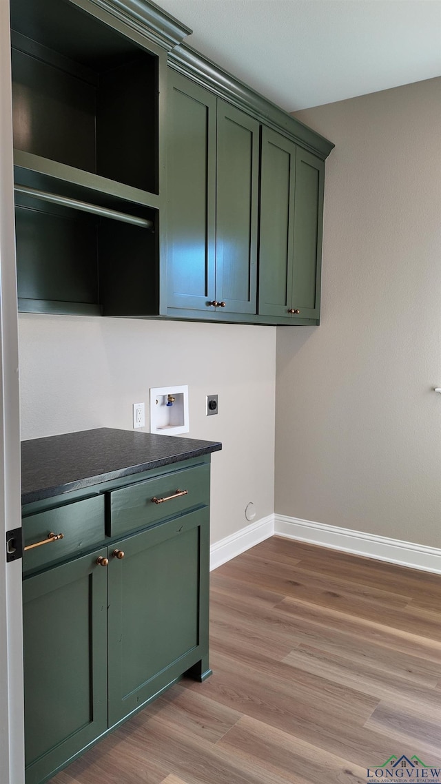 washroom featuring light wood-style flooring, washer hookup, baseboards, cabinet space, and electric dryer hookup