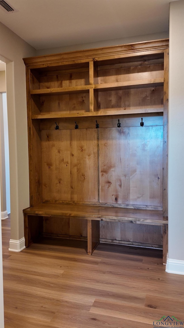 mudroom featuring baseboards, visible vents, and light wood finished floors