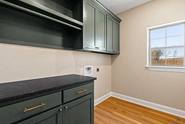 169 Andres Ln, Kilgore, TX 75662 - clothes washing area featuring hookup for an electric dryer, hookup for a washing machine, baseboards, light wood finished floors, and cabinet space
